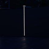 Vertical LED fence post light illuminating modern fence at night