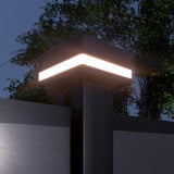 Solar LED fence post cap light illuminated at night on modern aluminum fence