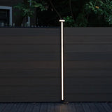 Vertical LED fence post light mounted on composite privacy fence at night