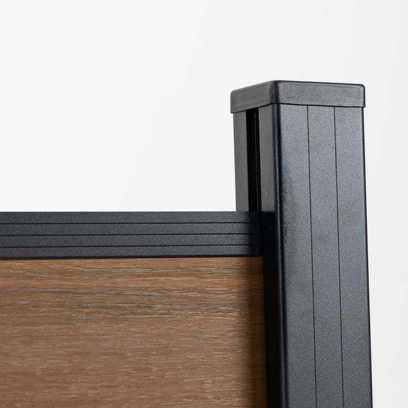Black aluminum fence post cap with wood grain composite fence panel, co-extruded composite outdoor fencing detail
