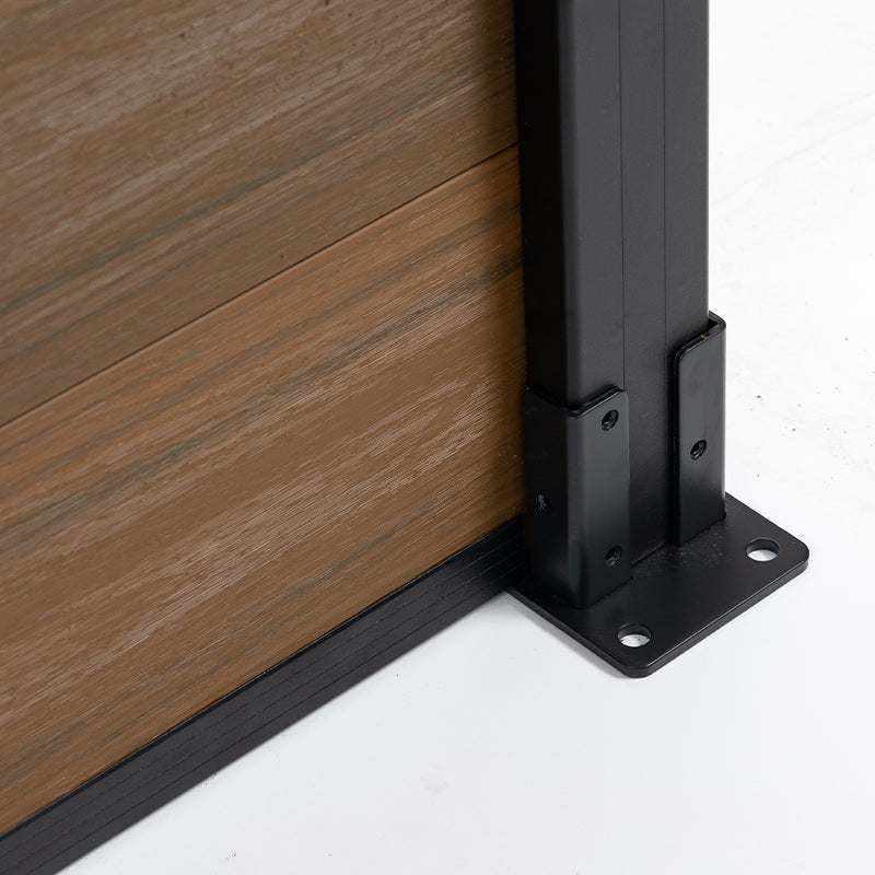 Wood grain composite fence panel bottom corner with black aluminum post base, co-extruded composite outdoor fencing hardware detail