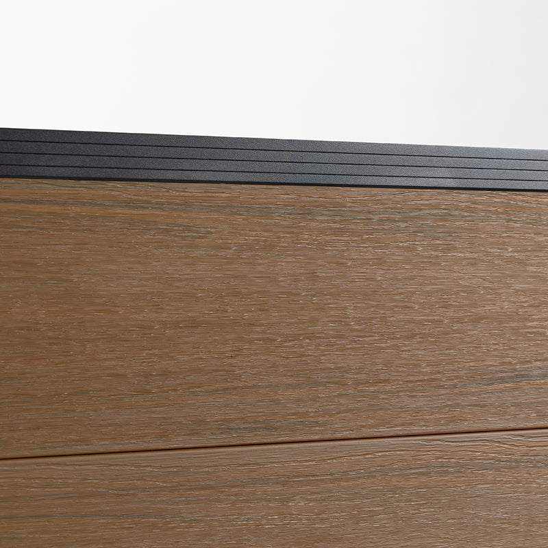 Wood grain composite fence board close up with black top rail, co-extruded composite outdoor fencing material