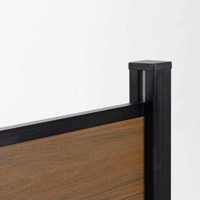 Wood grain composite fence panel top corner with black aluminum post cap, co-extruded composite outdoor fencing detail