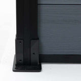 Black aluminum fence post base with gray composite fence panel, close up of outdoor privacy fencing hardware and mounting detail