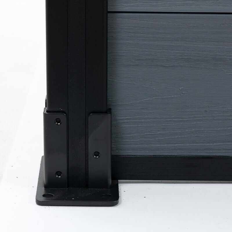 Black aluminum fence post base with gray composite fence panel, close up of outdoor privacy fencing hardware and mounting detail