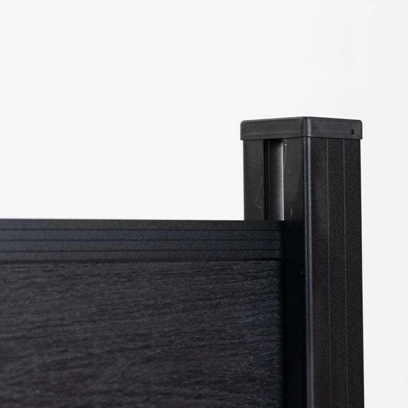 Close-up of composite fence panel top rail with black aluminum post and cap